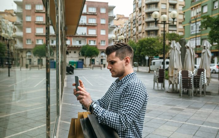 Man taking a photo of a shop window of a fashion store