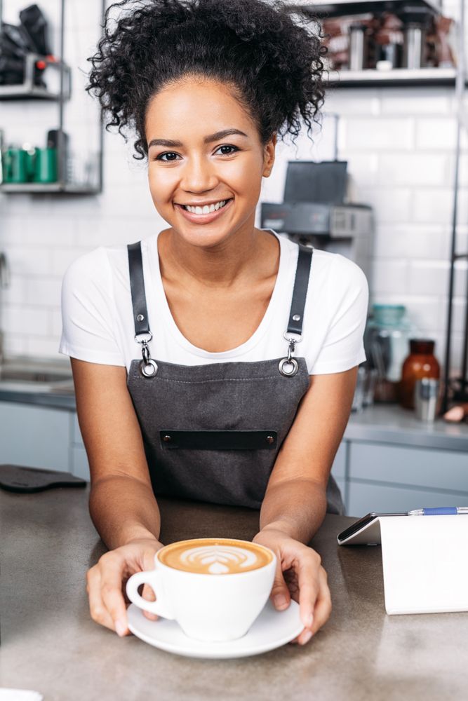 Smiling barista serving cappuccino