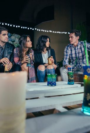 Group of friends talking and drinking at party outside