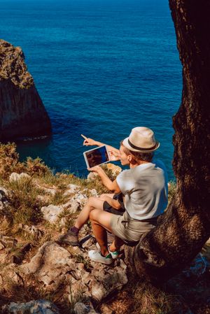 woman with tablet in hands on coast