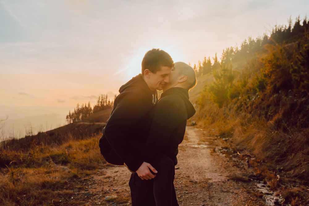 Men hugging and kissing in forest