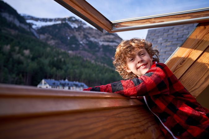 Smiling boy near window with mountain view