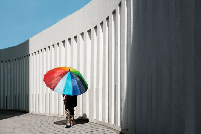 Person under a rainbow umbrella
