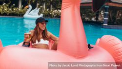 Woman relaxing at pool party with beer 481DJb