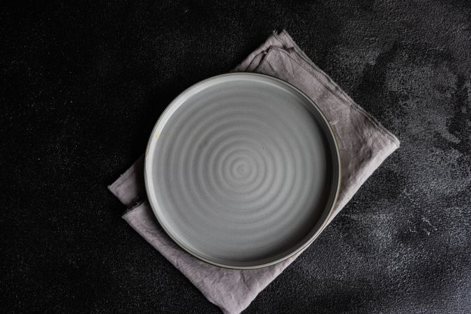 Grey empty plate and napkin as a table setting concept