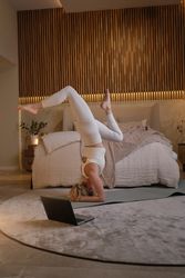 Slim woman doing yoga in bedroom