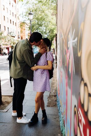 Happy couple kissing while walking in town