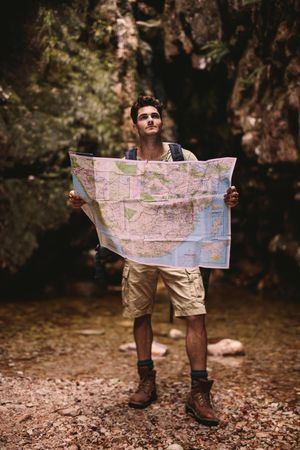 Skilled hiker using a map to find the route to the destination