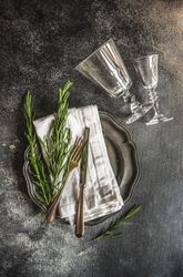 Table setting with fresh rosemary and glassware