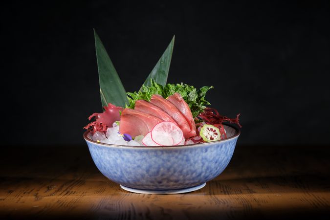 Ceramic plate with raw fish and vegetables