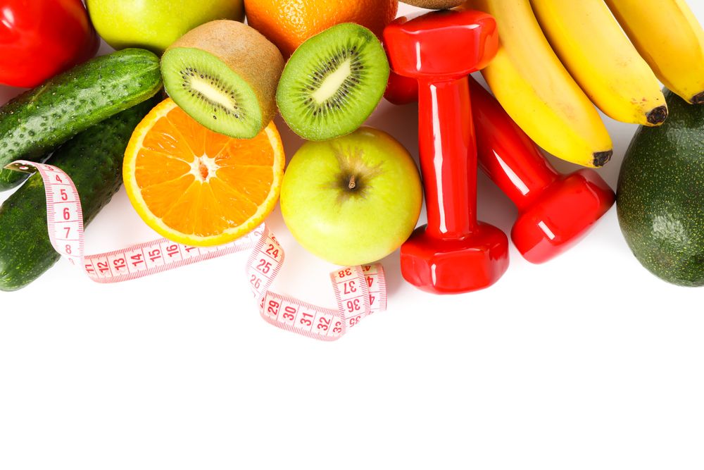 Dumbbells, measuring tape and fruits isolated on plain background