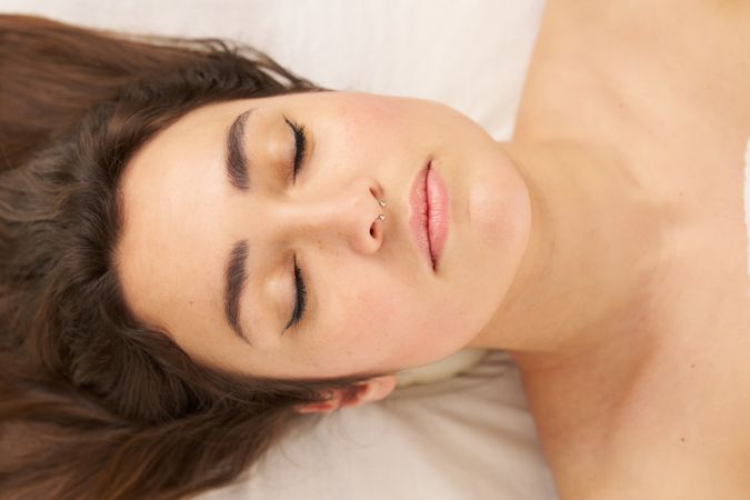 portrait of a woman lying on a stretcher with her eyes closed