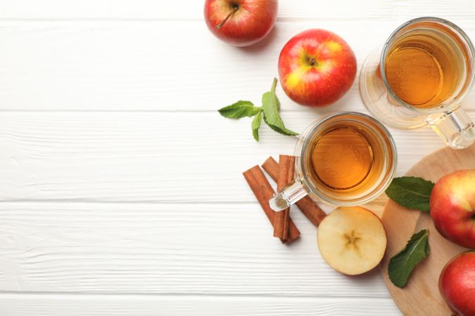 Composition with cider, cinnamon and apples on wooden background