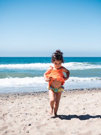 Cute twins girls playing on sandy beach