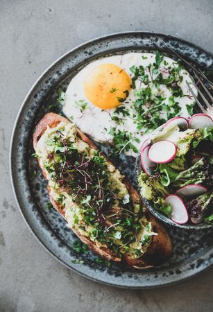 Avocado toast on sourdough bread with herbs and sprouts