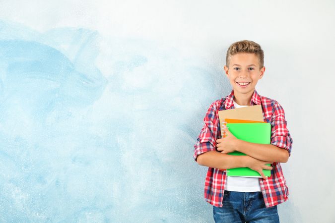 Boy with copybooks against color background, space for text