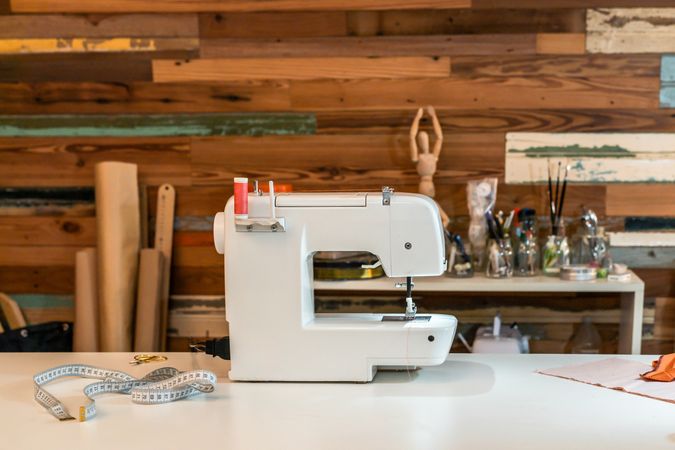 Modern sewing machine on table at fashion studio