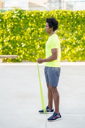 Man exercising his upper body with resistance bands outdoors