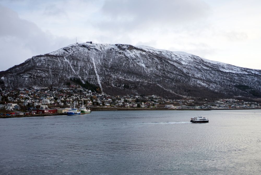 Landscape of sea bay next to big snowy cliff