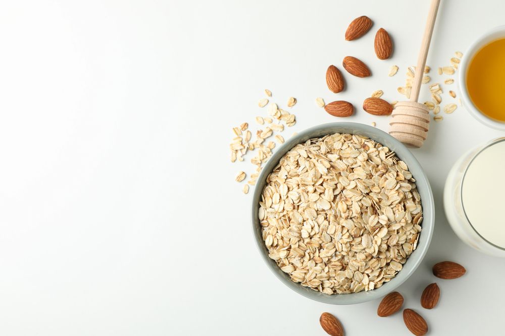 Composition with oatmeal flakes on plain background, top view. Cooking breakfast