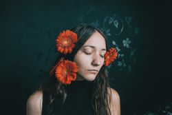 Studio portrait of woman with gerbera flowers on her hair