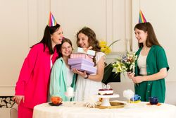 Girl in white dress receives gifts from family