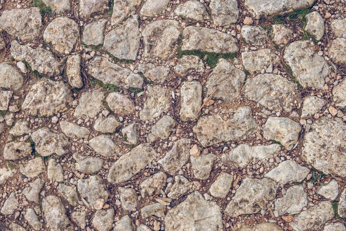 Old road with rough textured stones as background