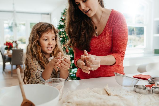 Mother and daughter preparing dough for Christmas cookies