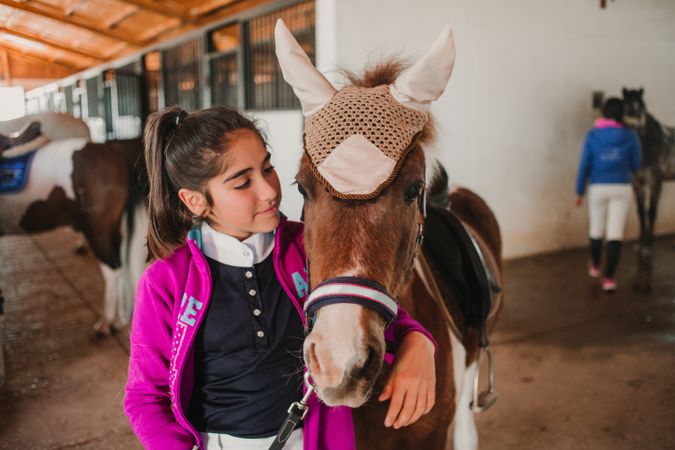 Girl with adorable pony in hat