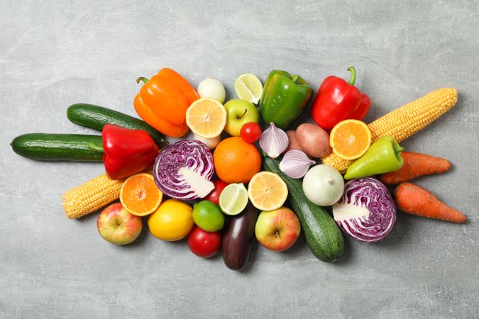 Different vegetables and fruits on grey background, top view