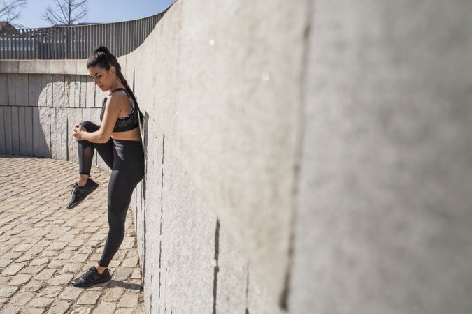 Woman stretching in park in sunny day