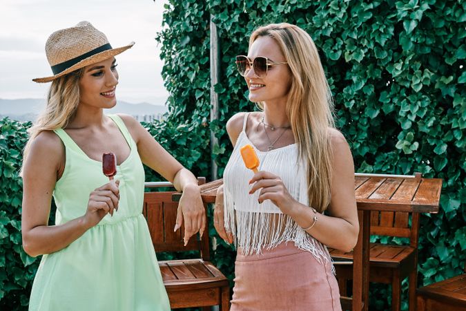 two young women eating ice-cream outdoors