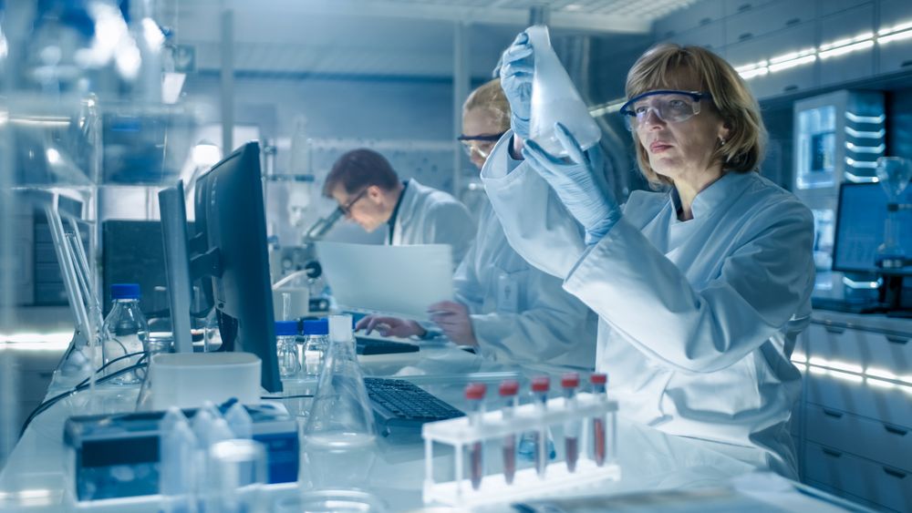 Female and Male Scientists Working on their Computers In Big Modern Laboratory.