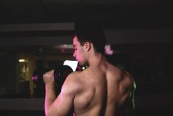 young fitness man doing weights
