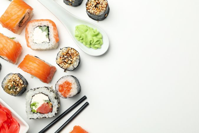 Sushi rolls and chopsticks on light background, space for text. Japanese food
