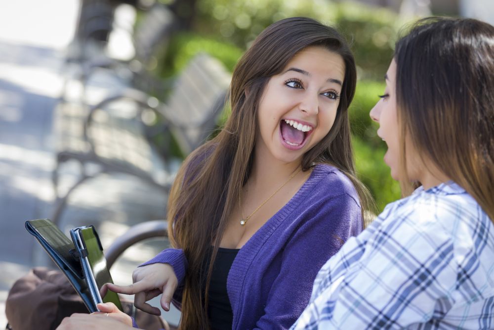 Two Happy Women Using Touch Pad Computer Outside