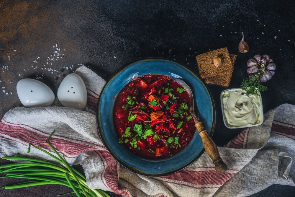 Top view of Ukrainian beetroot soup borscht on counter served with sour cream