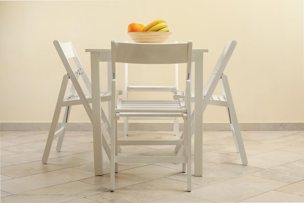 table with fruits and folding chairs in kitchen room