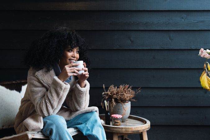 Smiling Black woman with cup of coffee