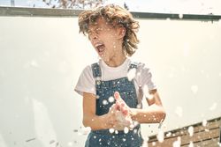 Screaming boy having fun while doing household chores