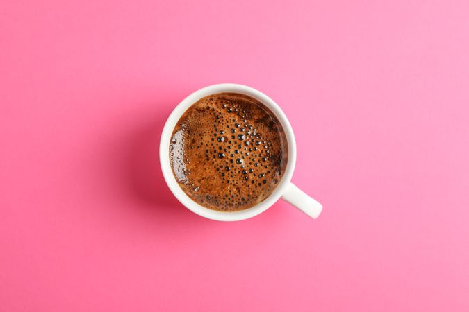 Cup of coffee on color background, space for text
