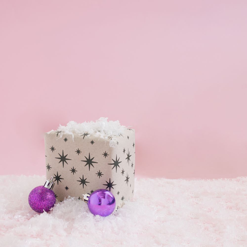 Starry giftwrap present with decorations sitting in snow