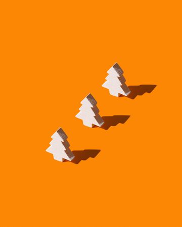 Three pine tree shaped blocks on an orange background