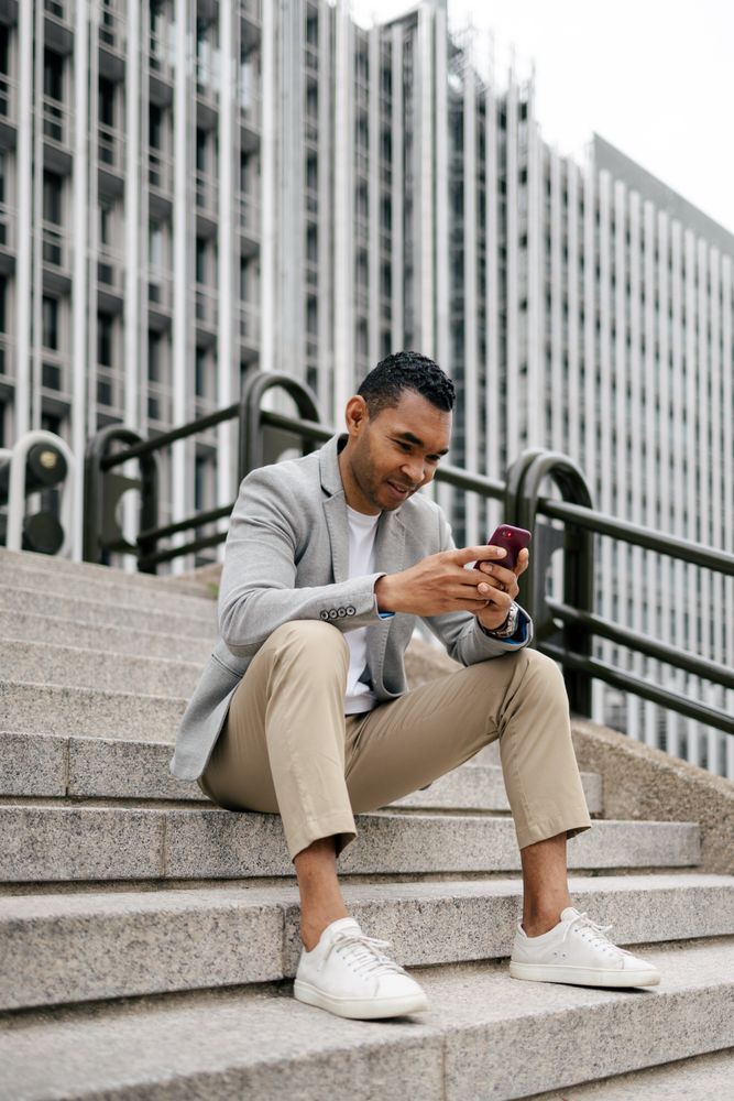 Man sitting on stairs using smartphone