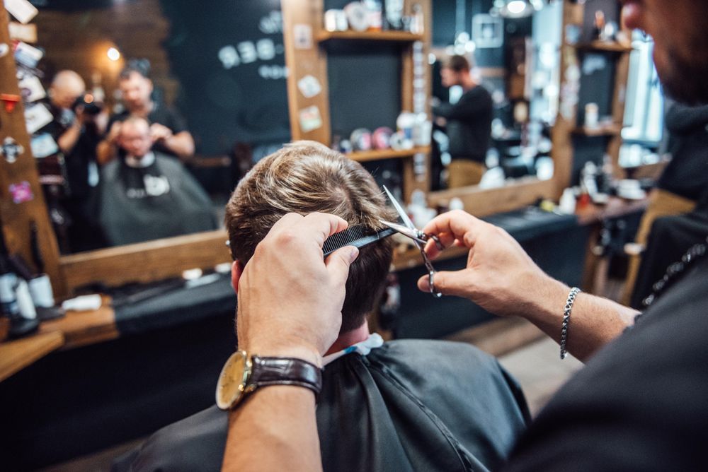 Barber cutting man's hair