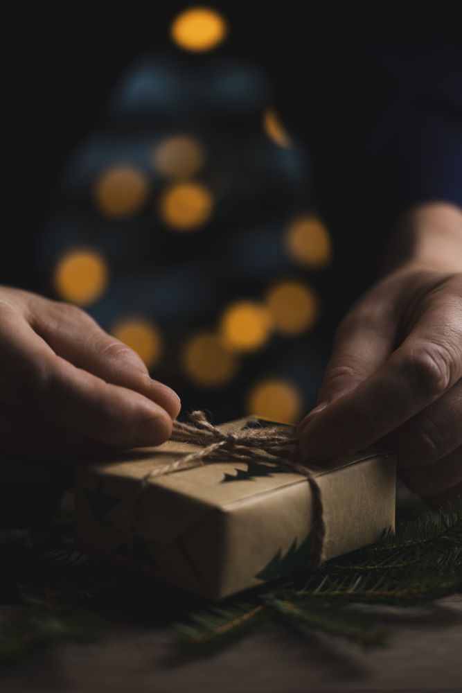 Man tying jute bow on Christmas gift