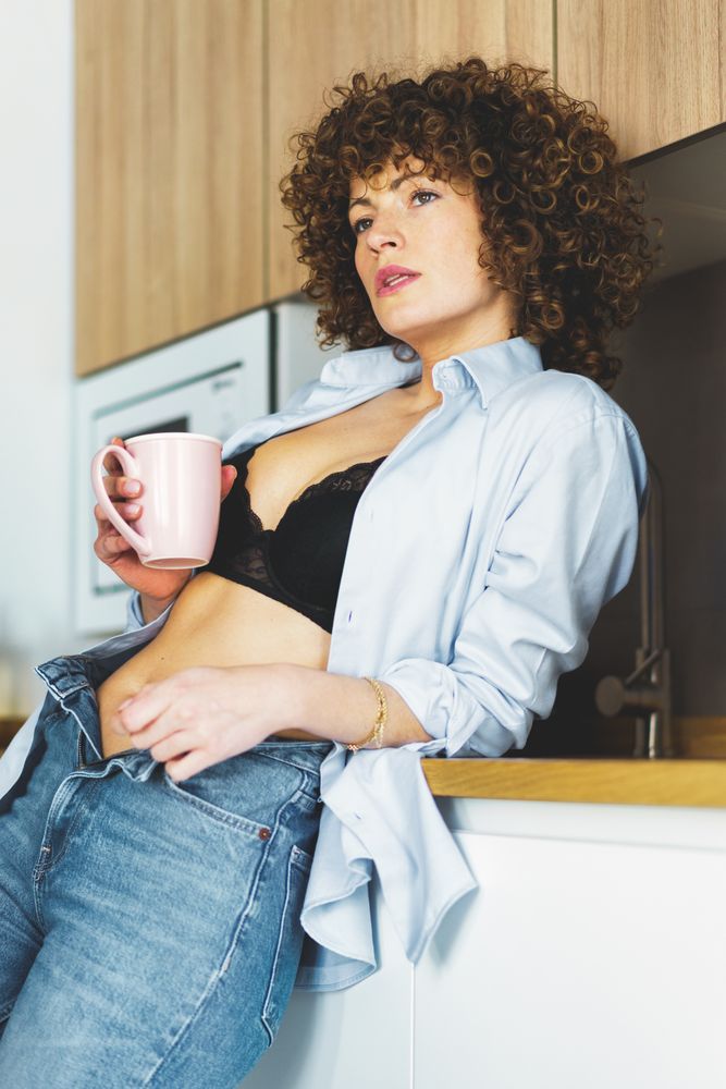 Woman lounging in her kitchen with coffee