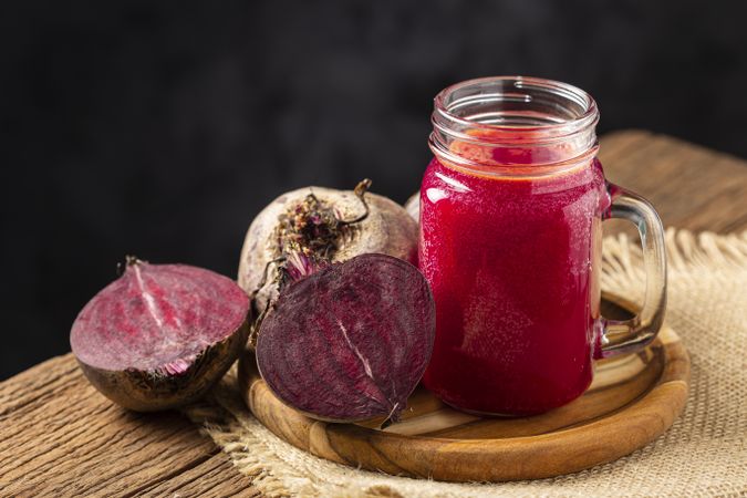 Red beet juice in a glass cup on the wooden table.