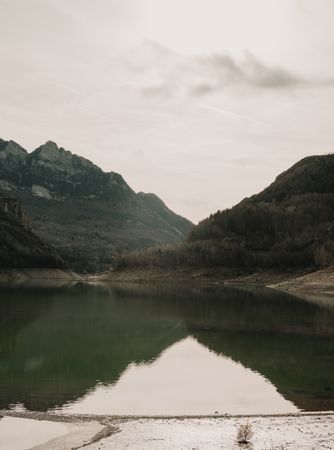 Wonderful lake between hills in snow and cloudy sky