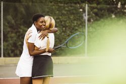 Portrait of two happy women in a tennis court